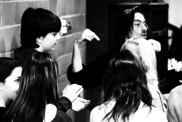 Shawn explaining movement to a group of young participants during Tango in schools