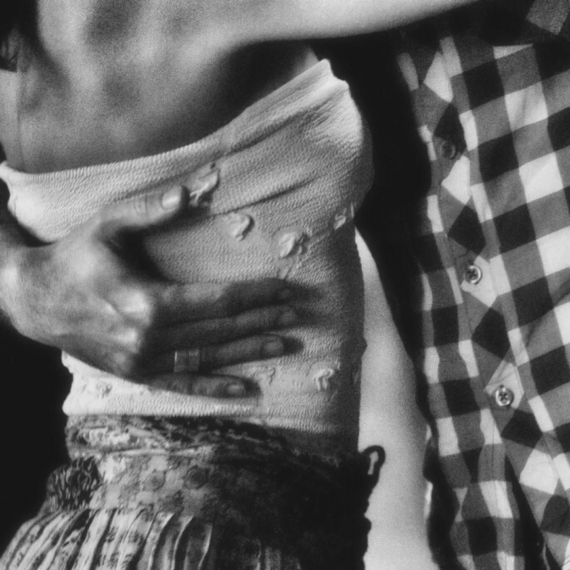 Gros plan sur l’abrazo et les mains de deux danseurs de tango